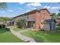 A side view of the brick townhome showcasing landscaping, a small storage unit and backyard space at 5678 Kingsport Dr, Sandy Springs, GA 30342