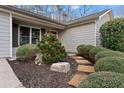 Charming home exterior featuring a landscaped yard, stone walkway, and well-maintained bushes at 3605 Chattahoochee Rd, Cumming, GA 30041