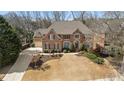 Aerial view of a brick home with a long driveway and lush landscaping at 1270 Seale Dr, Alpharetta, GA 30022