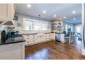 Spacious kitchen with white cabinets, dark countertops, hardwood floors, and open shelving at 902 E Ponce De Leon Ave, Decatur, GA 30030