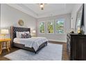 Cozy bedroom featuring tray ceilings, hardwood floors, and three large windows at 660 Timm Valley Ne Rd, Atlanta, GA 30305