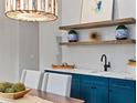 Stylish dining room featuring a bar with open shelving, blue cabinets, and a modern light fixture at 660 Timm Valley Ne Rd, Atlanta, GA 30305