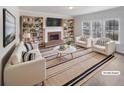 Bright living room featuring a brick fireplace, built-in bookshelves, and large windows at 5132 Silhouette Sw Ln, Mableton, GA 30126