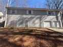 Exterior view of the back of a two-story home featuring two doors and a two-car garage at 5080 Springtree Ct, Lithonia, GA 30038