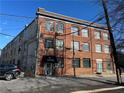 Exterior view of brick apartment building with black awning, street view and car at 172 Haynes Sw St # 102, Atlanta, GA 30313