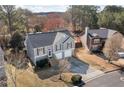 Gray home with two-car garage and manicured lawn nestled among mature trees in a suburban neighborhood at 15 Southview Dr, Cartersville, GA 30121