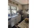 Well-lit kitchen with white cabinets, stylish backsplash, stainless steel appliances, and a modern sink at 502 Turner Ave, Palmetto, GA 30268