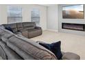 Comfortable living room featuring a sectional sofa and fireplace with a large screen TV at 938 Blue Juniper Cir, Loganville, GA 30052