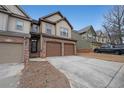 Street view of townhome featuring neutral siding, brick accents, and two car garage at 1211 Grampian Pass # 15, Marietta, GA 30008