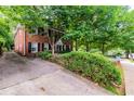 Side view of brick home with lush trees, a long driveway, and manicured front yard at 830 Barnett Ne St # 8, Atlanta, GA 30306