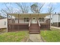 Charming home featuring a covered porch, wooden deck, and mature landscaping at 214 Maple St, Atlanta, GA 30354