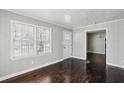 Bright living room featuring hardwood floors, freshly painted walls, and a front door at 214 Maple St, Atlanta, GA 30354