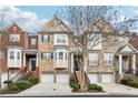 Attractive brick townhome featuring multiple units, covered entrances, and attached garages at 2959 Rivergreen Se Ln, Atlanta, GA 30339
