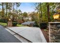 A long driveway leads up to the house, framed by stone pillars and manicured greenery at 5525 Whitner Dr, Sandy Springs, GA 30327