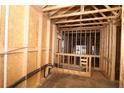 An unfinished room with exposed beams and framework showing pre-installed plumbing and electrical at 2017 Ripple Park Bend, Canton, GA 30114