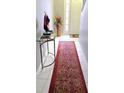 Inviting entryway featuring a stylish console table, red oriental rug, and a decorative vase with flowers at 2403 Brianna Dr, Hampton, GA 30228