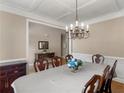 Formal dining room featuring coffered ceilings, chandelier, and wainscoting at 1258 Mcallistar Dr, Locust Grove, GA 30248