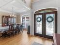 Elegant foyer with hardwood floors, ornate double doors, and coffered ceilings at 1258 Mcallistar Dr, Locust Grove, GA 30248