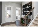 Charming entryway features a decorative table, stairway, and a view into a bedroom through an open door at 216 Birchwood Row, Holly Springs, GA 30115