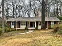 Welcoming front exterior with a well-maintained lawn, mature trees and manicured landscape at 2480 Glenbonnie Dr, Dunwoody, GA 30360