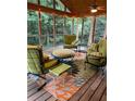 Cozy screened porch with comfortable seating and a view of the wooded backyard at 2480 Glenbonnie Dr, Dunwoody, GA 30360