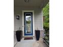 Stylish front door with glass panel, flanked by tall planters, offering a warm entrance to the home at 3157 Oakdale Rd, Hapeville, GA 30354