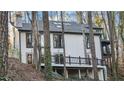 View of the back exterior of the home with a deck overlooking lush greenery at 4830 Rebel Nw Trl, Sandy Springs, GA 30327