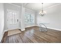 Dining area with modern chandelier, wood floors, bright window and neutral color palette at 2098 Bridgewater Pass, Hampton, GA 30228