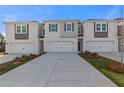 Three-unit townhouse-style building with white painted brick, garages, and landscaping at 313 Heavenly Hollow Pl, Mcdonough, GA 30253