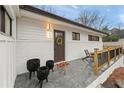 Inviting front entrance with a wood door and a cozy seating area on the tile patio at 2111 Drew Valley Ne Rd, Brookhaven, GA 30319
