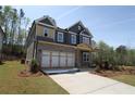 Two-story home featuring brick and gray siding, with a spacious driveway and attached two-car garage at 4445 Beechnut Cir, Cumming, GA 30028