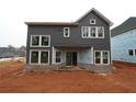 Back exterior of a two-story new construction home with multiple windows and sliding glass doors at 4445 Beechnut Circle, Cumming, GA 30028