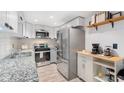 Bright kitchen boasting stainless steel refrigerator, granite counters, stainless steel appliances, white cabinets and stylish decor at 6851 Roswell Rd # M12, Sandy Springs, GA 30328