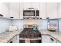 Close up of a well-appointed kitchen featuring granite counters, stainless steel appliances, and white subway tile backsplash at 6851 Roswell Rd # M12, Sandy Springs, GA 30328
