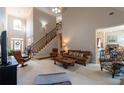 Spacious living room with high ceilings, staircase, and view into the dining room at 1030 Silver Thorne Dr, Loganville, GA 30052