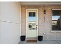 Inviting front door with glass panel, brick surround, and decorative details at 127 Harlow Cir, Roswell, GA 30076