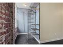 Modern open closet with metal shelving and rod, alongside exposed brick wall and natural light at 800 Peachtree Ne St # 8508, Atlanta, GA 30308