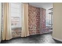 Stylish living room with brick wall and ample natural light from windows with neutral-colored drapes at 800 Peachtree Ne St # 8508, Atlanta, GA 30308