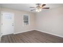 Bright living room featuring hardwood floors, a white front door, a ceiling fan, and natural light at 3005 Hidden Dr, Lawrenceville, GA 30044