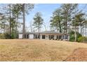 Charming single-story home featuring a classic white brick exterior and well-manicured lawn at 6256 Mountain Brook Way, Sandy Springs, GA 30328