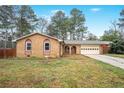 A single-story brick home with a well-maintained lawn and an attached garage is seen on a sunny day at 1495 Harbour Oaks Rd, Tucker, GA 30084