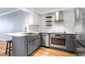 A well-lit kitchen featuring subway tile backsplash, open shelving, a farmhouse sink and modern stainless steel appliances at 2870 Pharr Court South Nw # 2008, Atlanta, GA 30305