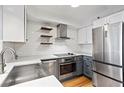 Modern kitchen with stainless steel appliances, white cabinets, gray lower cabinets, and farmhouse sink under recessed lighting at 2870 Pharr Court South Nw # 2008, Atlanta, GA 30305