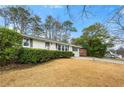 Inviting single-story home with a well-manicured lawn and mature trees, showcasing curb appeal at 1558 Grant Ne Dr, Atlanta, GA 30319