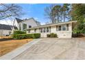 Beautiful white brick home with a well-maintained lawn and long driveway at 1558 Grant Ne Dr, Atlanta, GA 30319