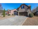 Exterior elevation of the home with a well-kept lawn and long concrete driveway at 4972 Arbor View Nw Pkwy, Acworth, GA 30101