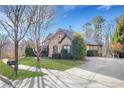 Beautiful home showcasing manicured lawn, mature trees, and a convenient driveway at 772 Crescent Cir, Canton, GA 30115