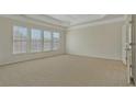 This main bedroom has neutral carpeting, three bright windows, and tray ceiling at 4669 Prater Se Way, Smyrna, GA 30080