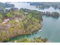 Stunning aerial view of lakefront home surrounded by verdant trees and blue waters perfect for relaxation at 5975 P W A Dr, Cumming, GA 30041