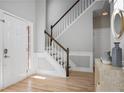 Inviting foyer features hardwood floors, a staircase with white and wood banister, and a decorative mirror at 4525 Chelton Se Ct, Smyrna, GA 30080